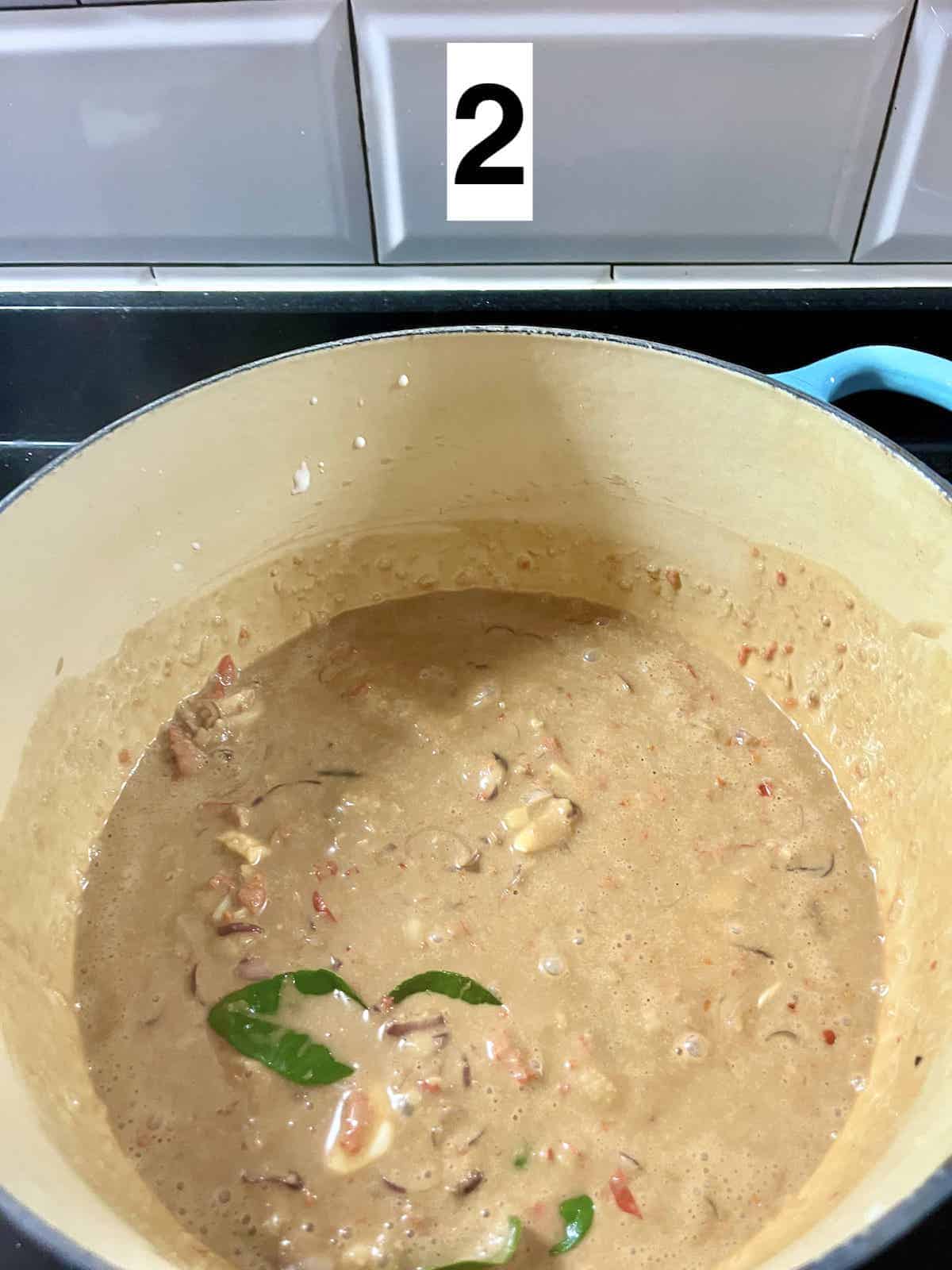 A Dutch oven with sambal, coconut curry and kaffir lime leaves.
