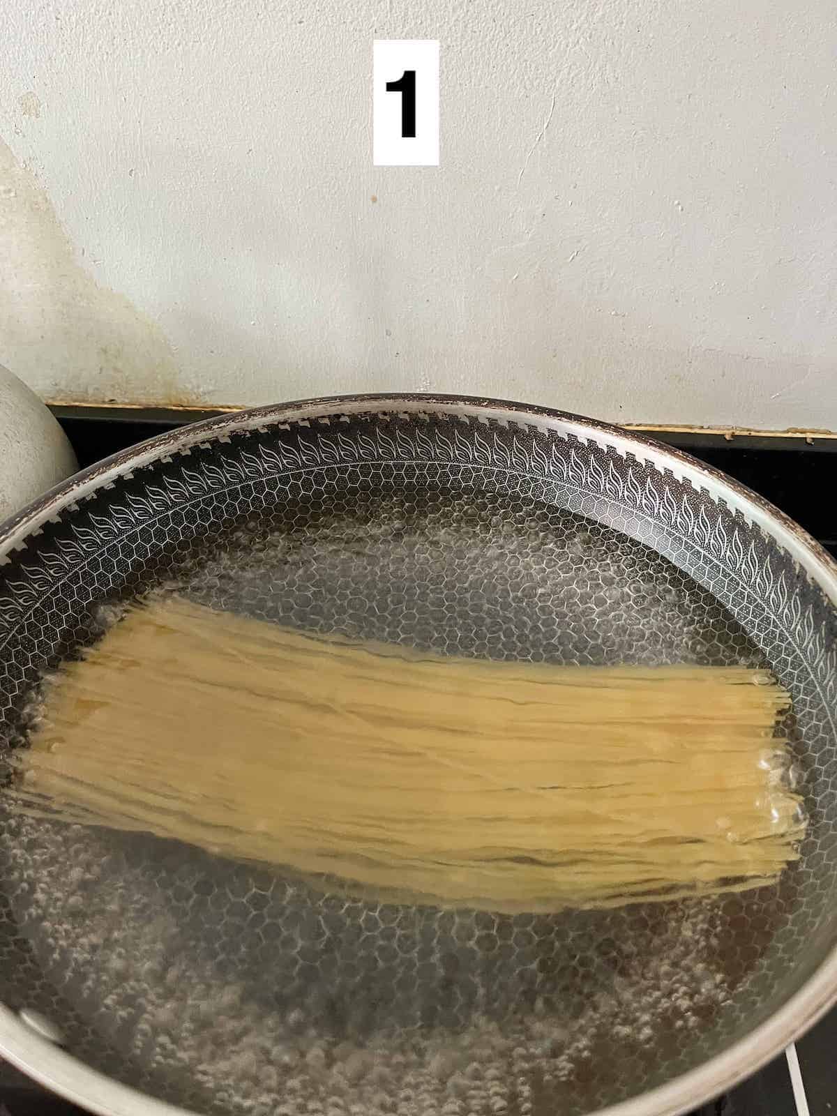 Boiling spaghetti in a wok.