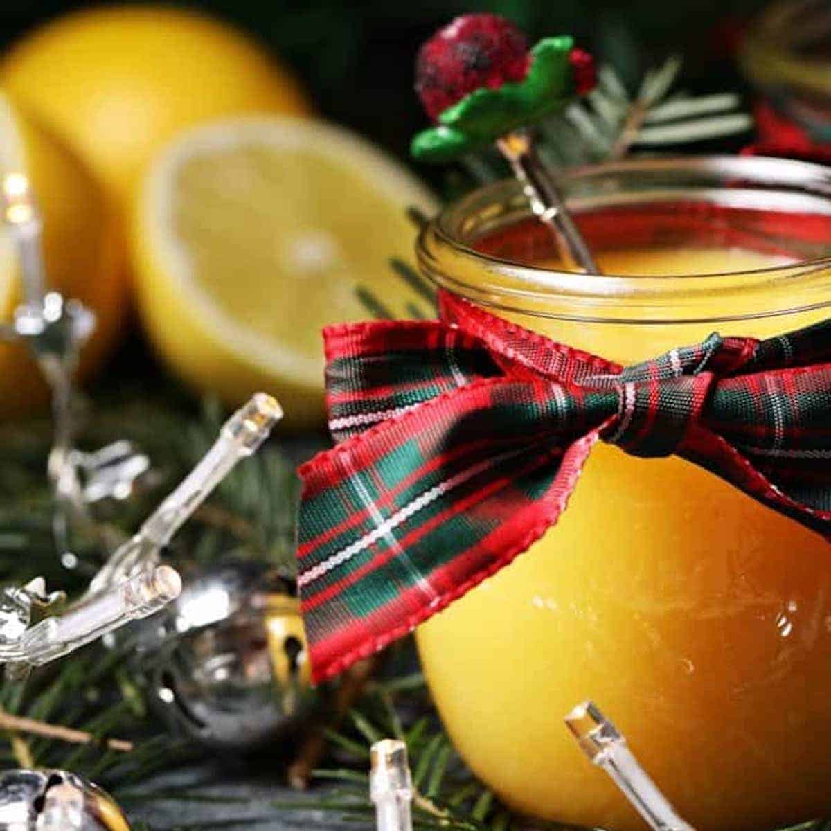 Close-up of a glass jar of Eggnog Curd, wrapped as a Christmas gift.