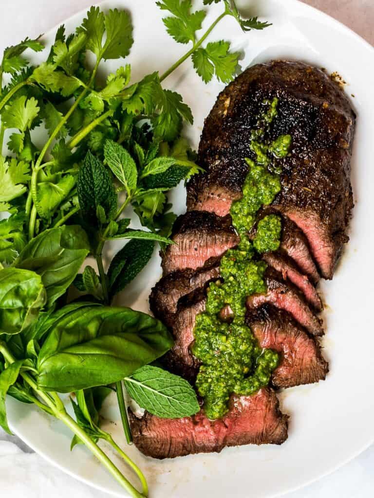 Sliced Asian Flank steak with greens on a plate