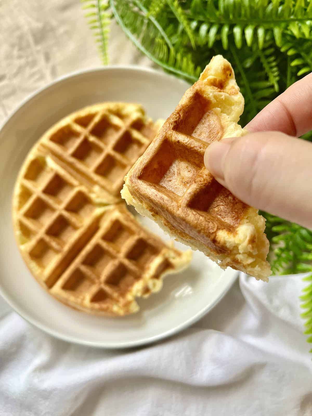 Holding up a slice of cheese waffle mochi.