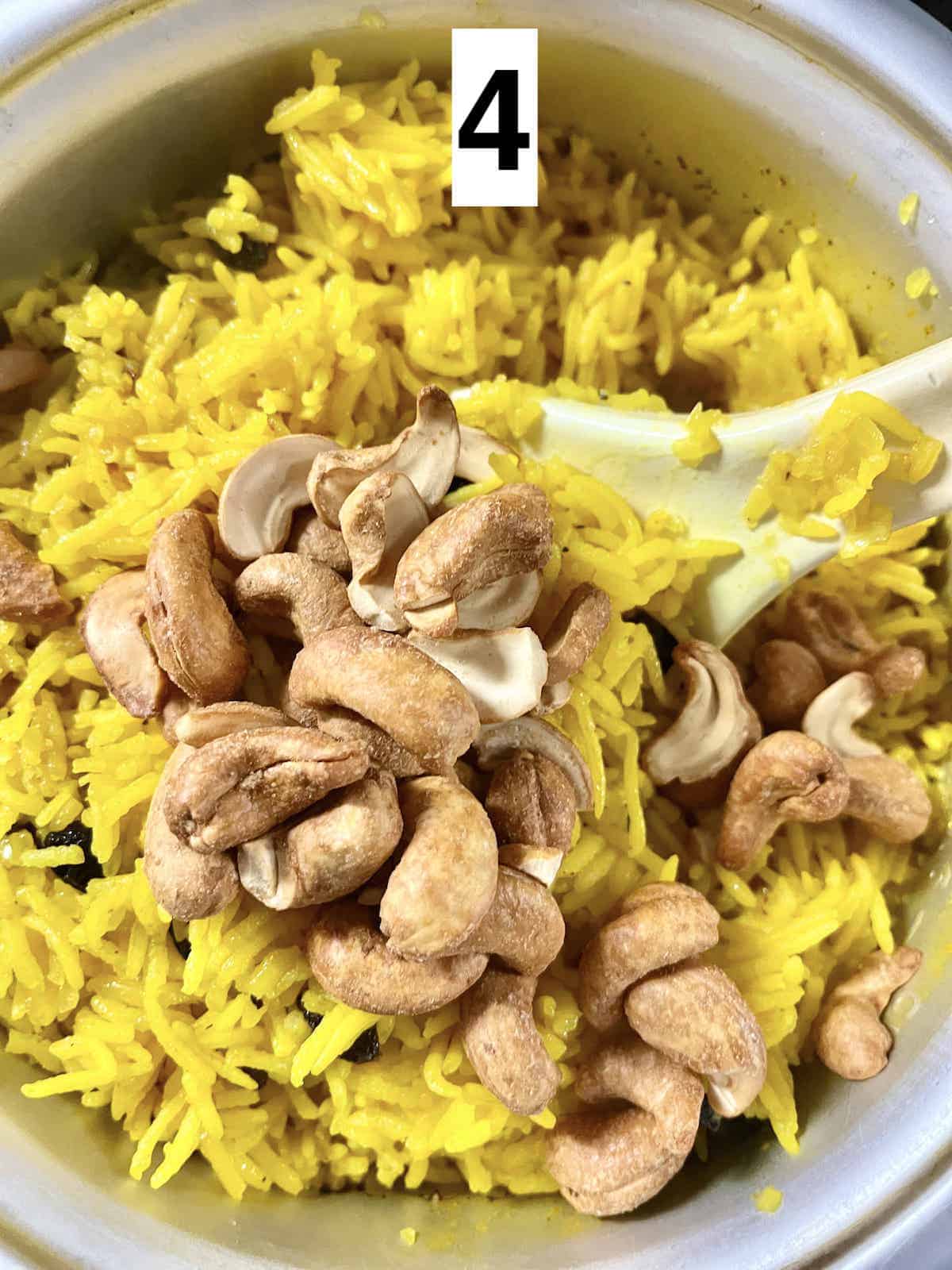 Stirring roasted cashew nuts into golden turmeric rice.