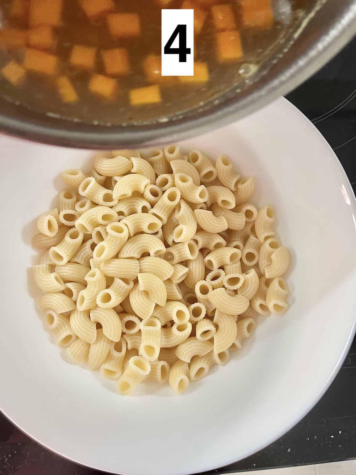 Pouring soup into a bowl of macaroni.