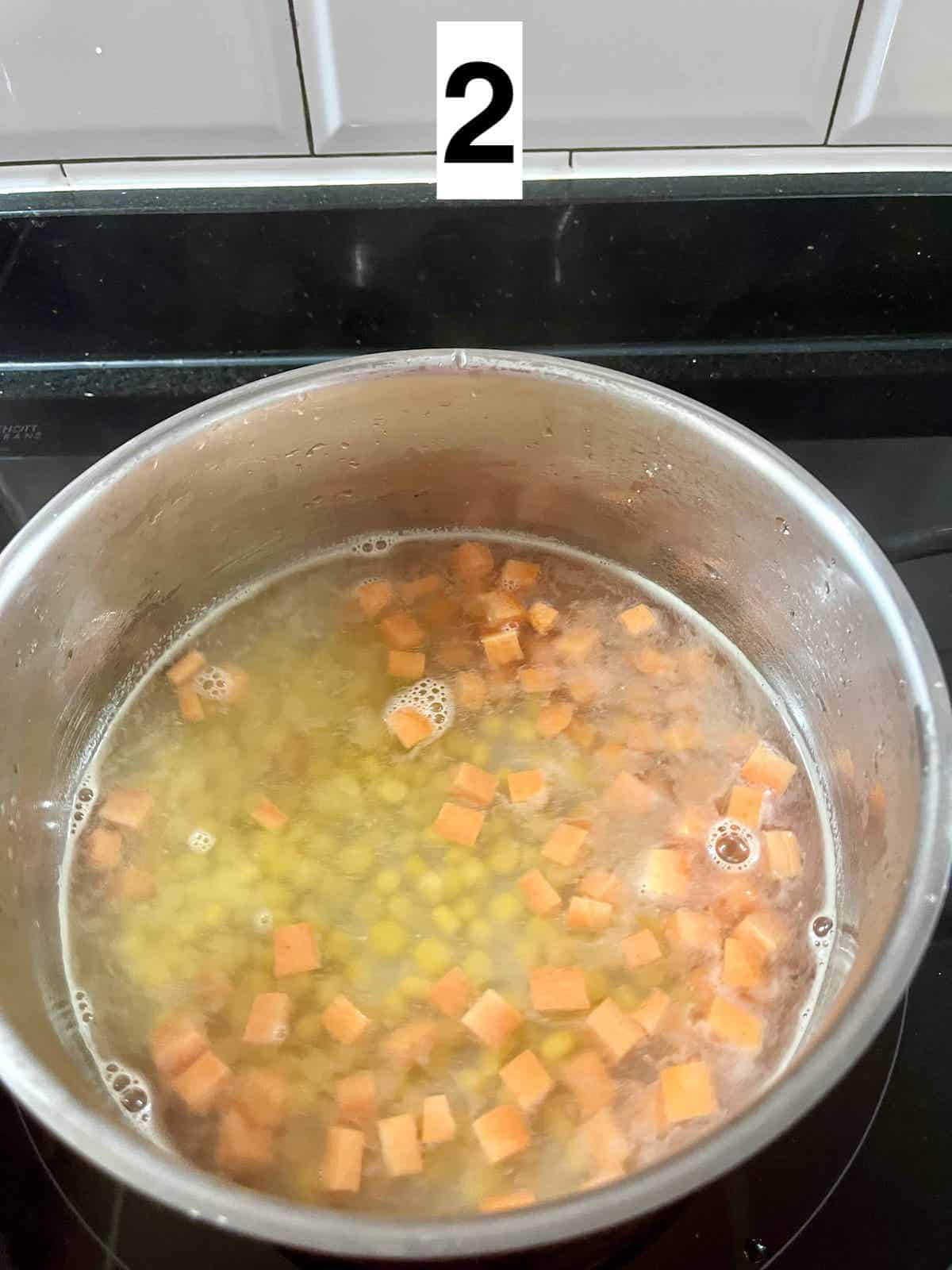 Bringing corn and carrots to the boil.
