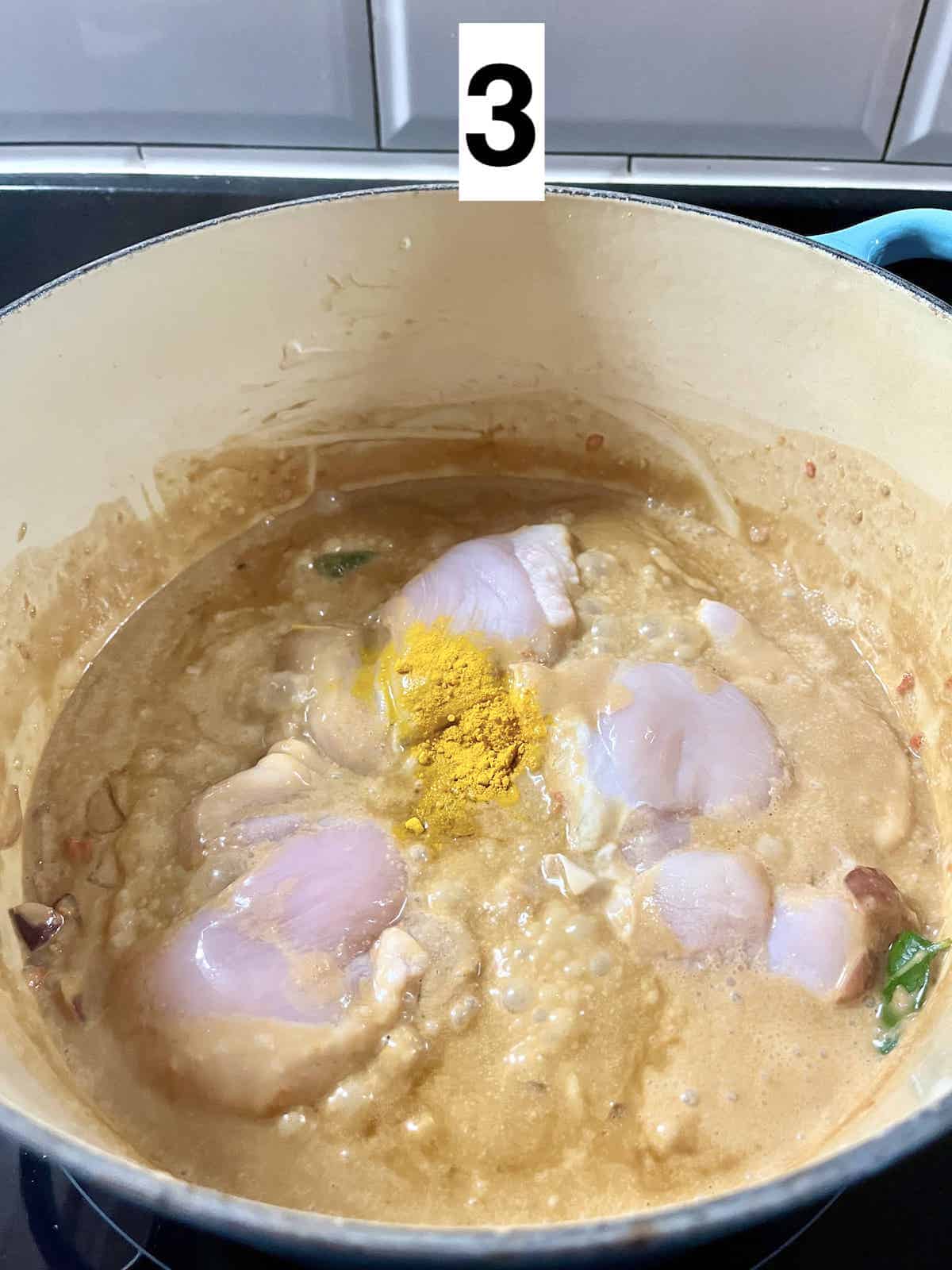 Skinless, boneless chicken in sambal coconut sauce, with turmeric powder on top.