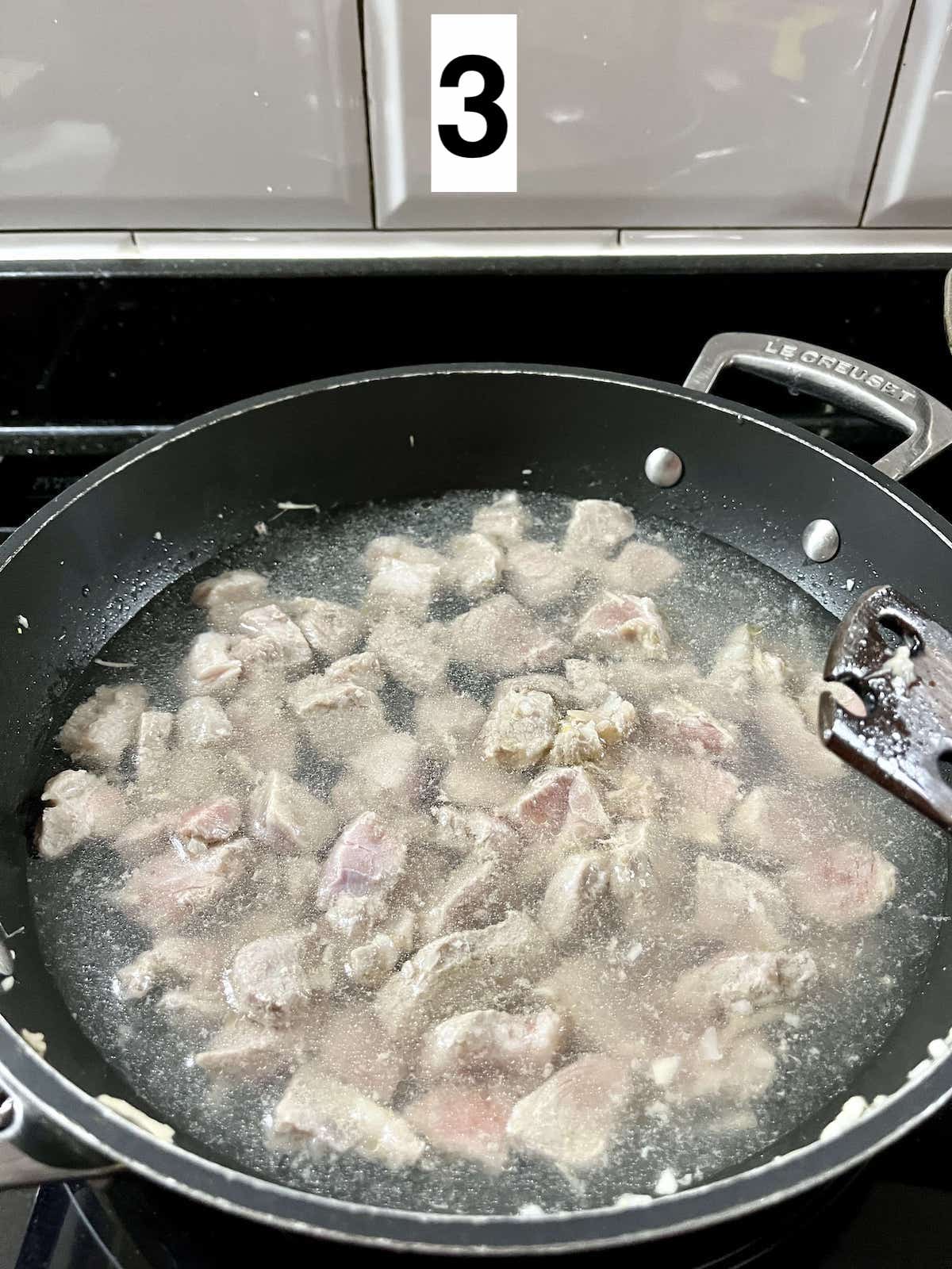 Cooking pork in water in a pan.