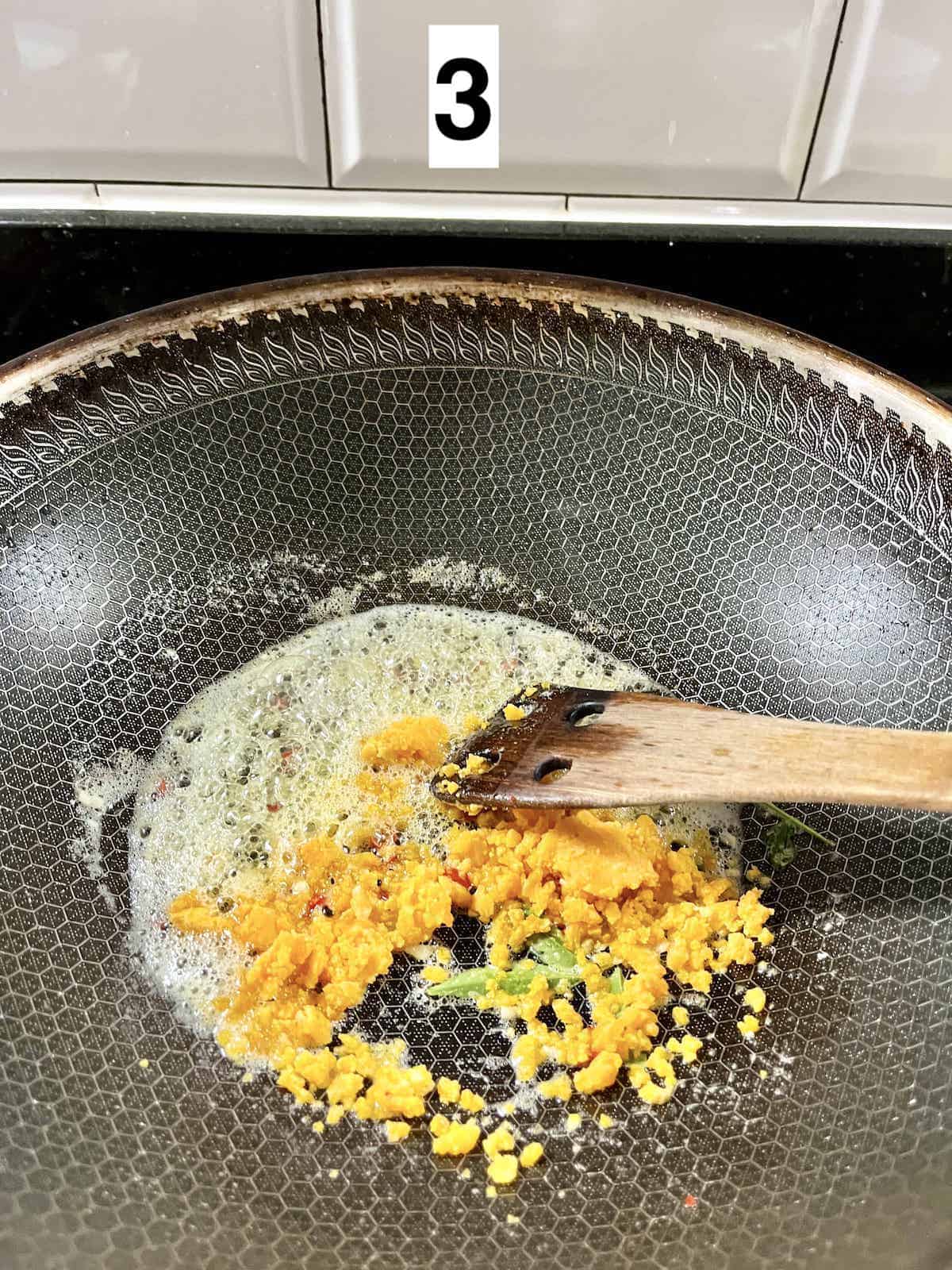 Stir frying mashed up salted egg yolk into butter.