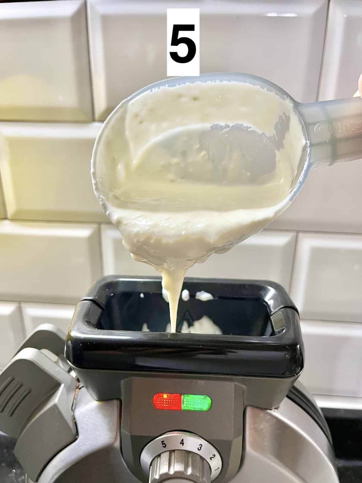 Pouring mochi waffle batter down a vertical waffle iron.