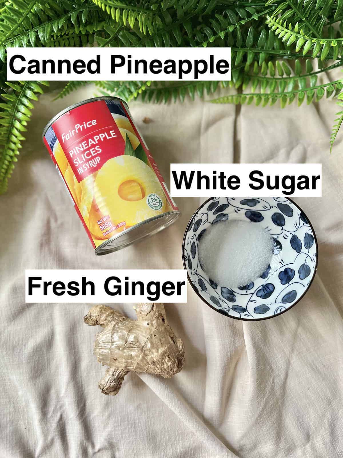 A can of pineapple next to fresh ginger root and white sugar.