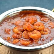 Red prawn curry in a metal pot.