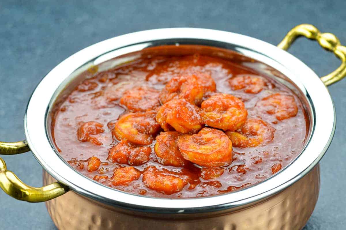 Red prawn curry in a metal pot.