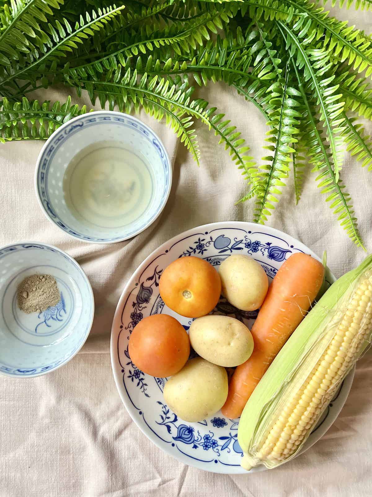 The ingredients needed for ABC Soup on a tablecloth.