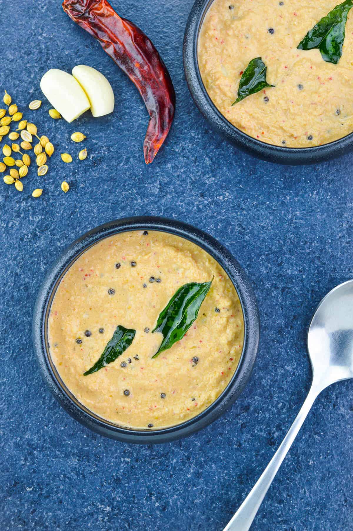 Coconut and tamarind curry in a black bowl.