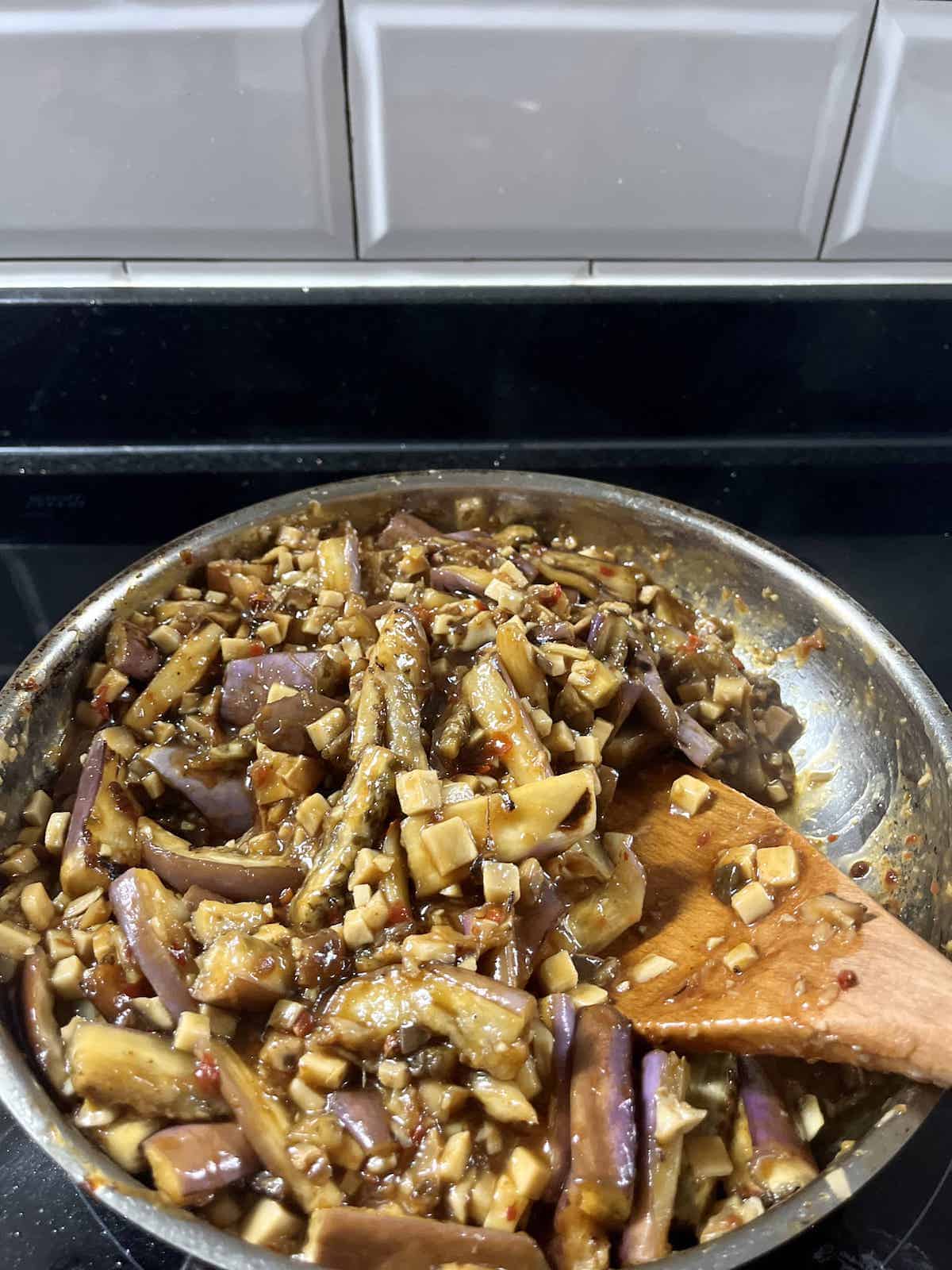 A pan full of Chinese sauteed eggplant that was made without dark soy sauce.