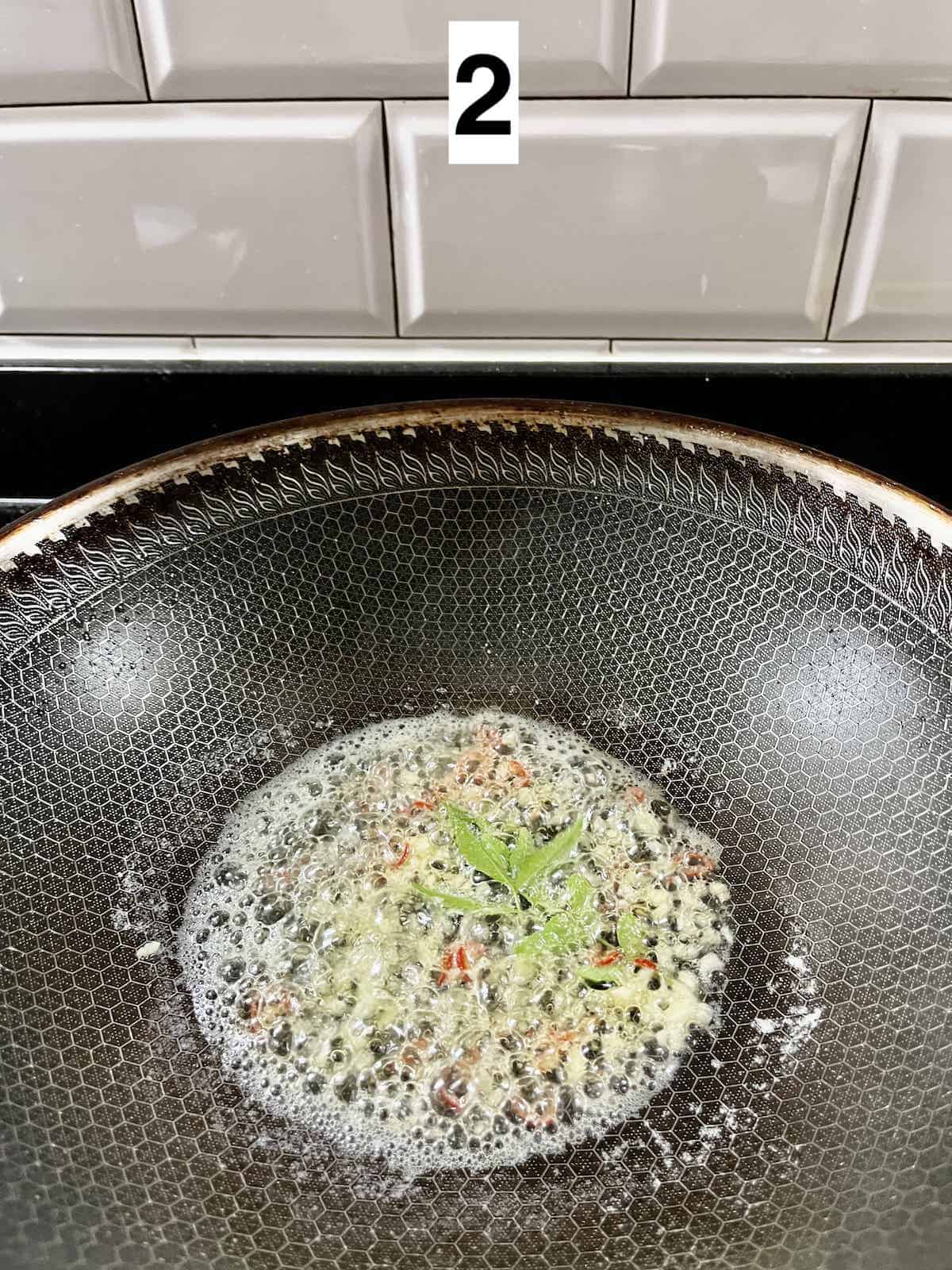 Sauteeing red chili padi and curry leaves in butter.