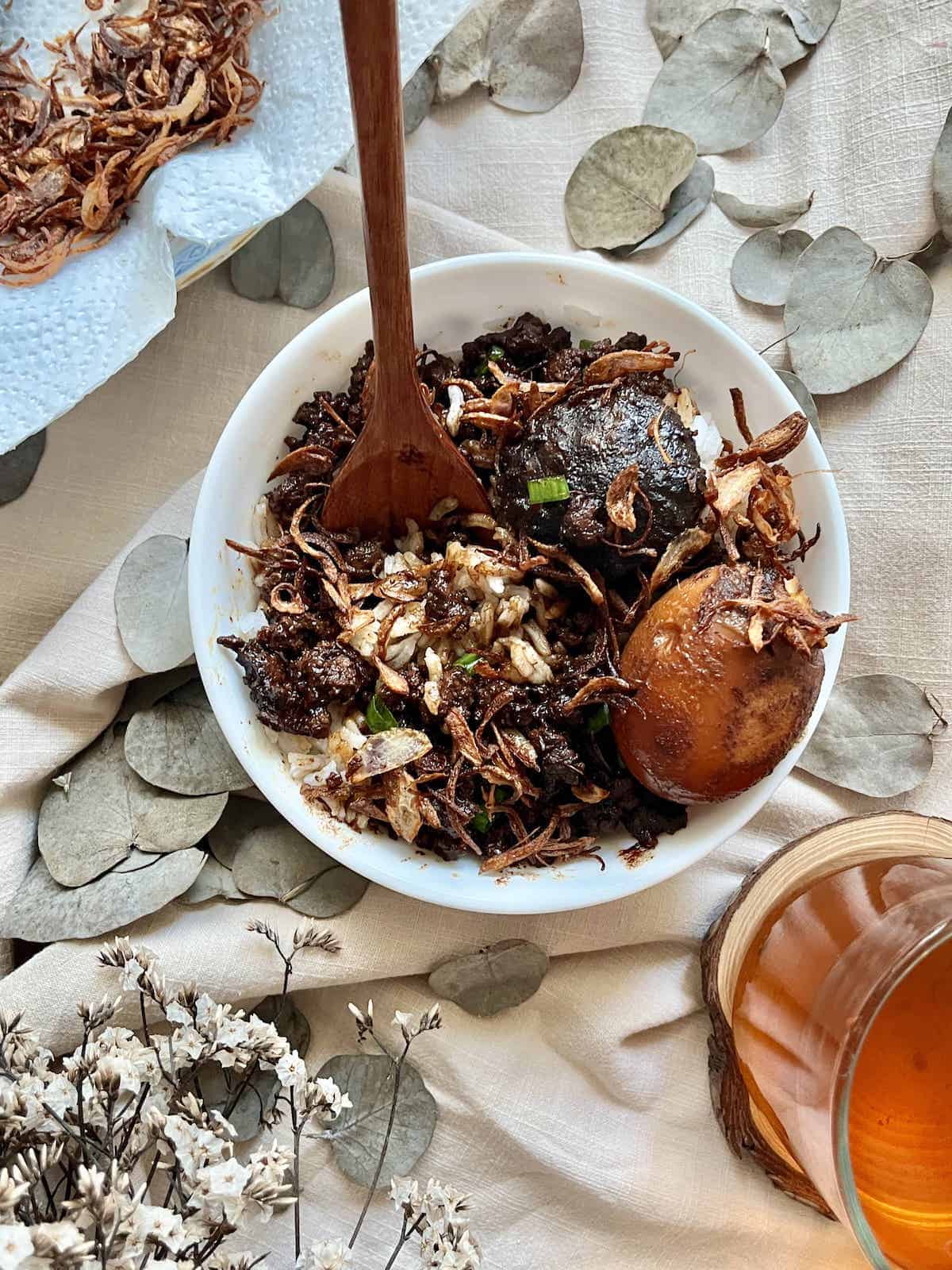 A bowl of braised pork rice with hard boiled egg and fried shallots.