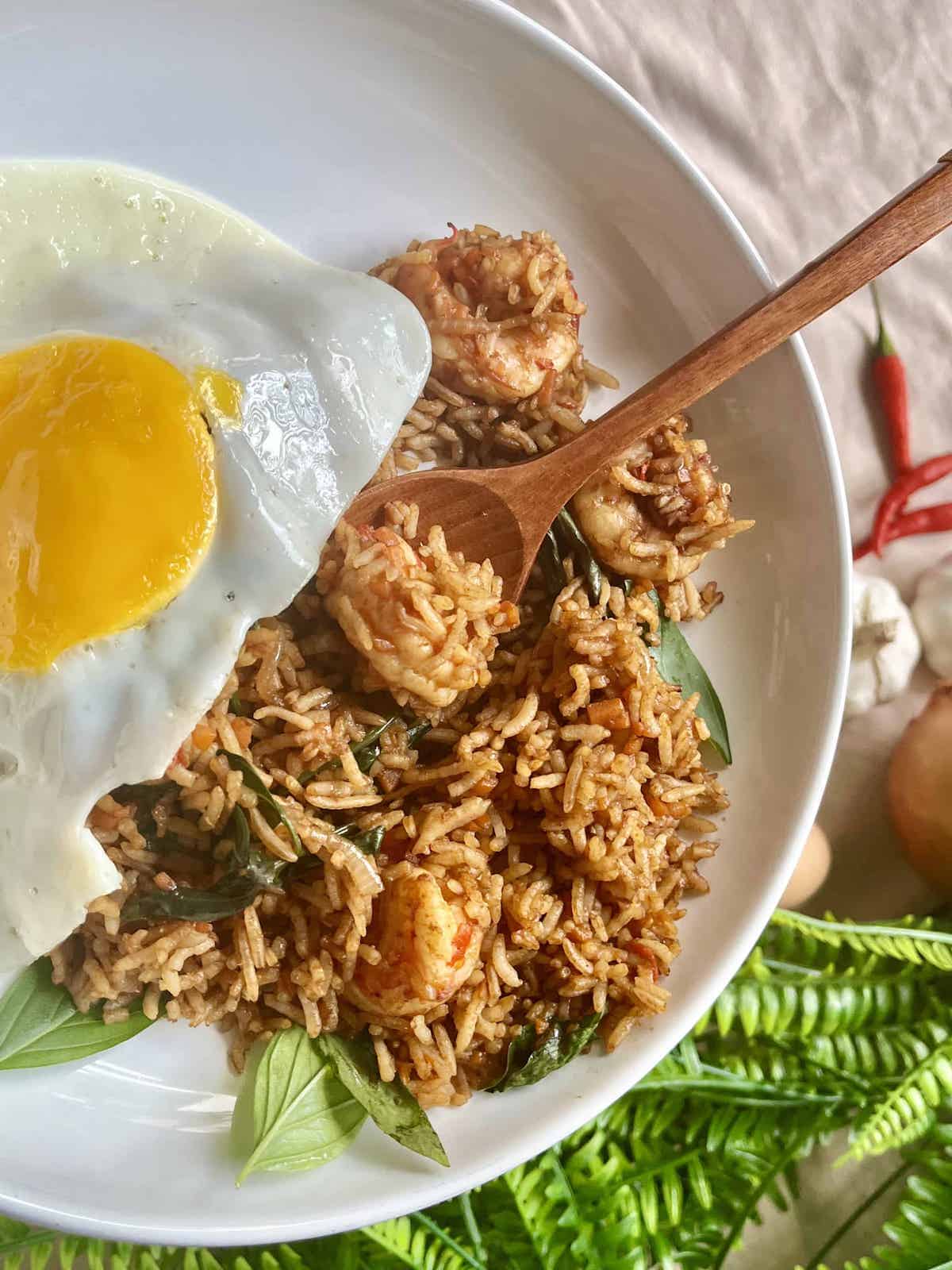 Close-up of a plate of Thai fried rice with shrimp and a sunny side egg.
