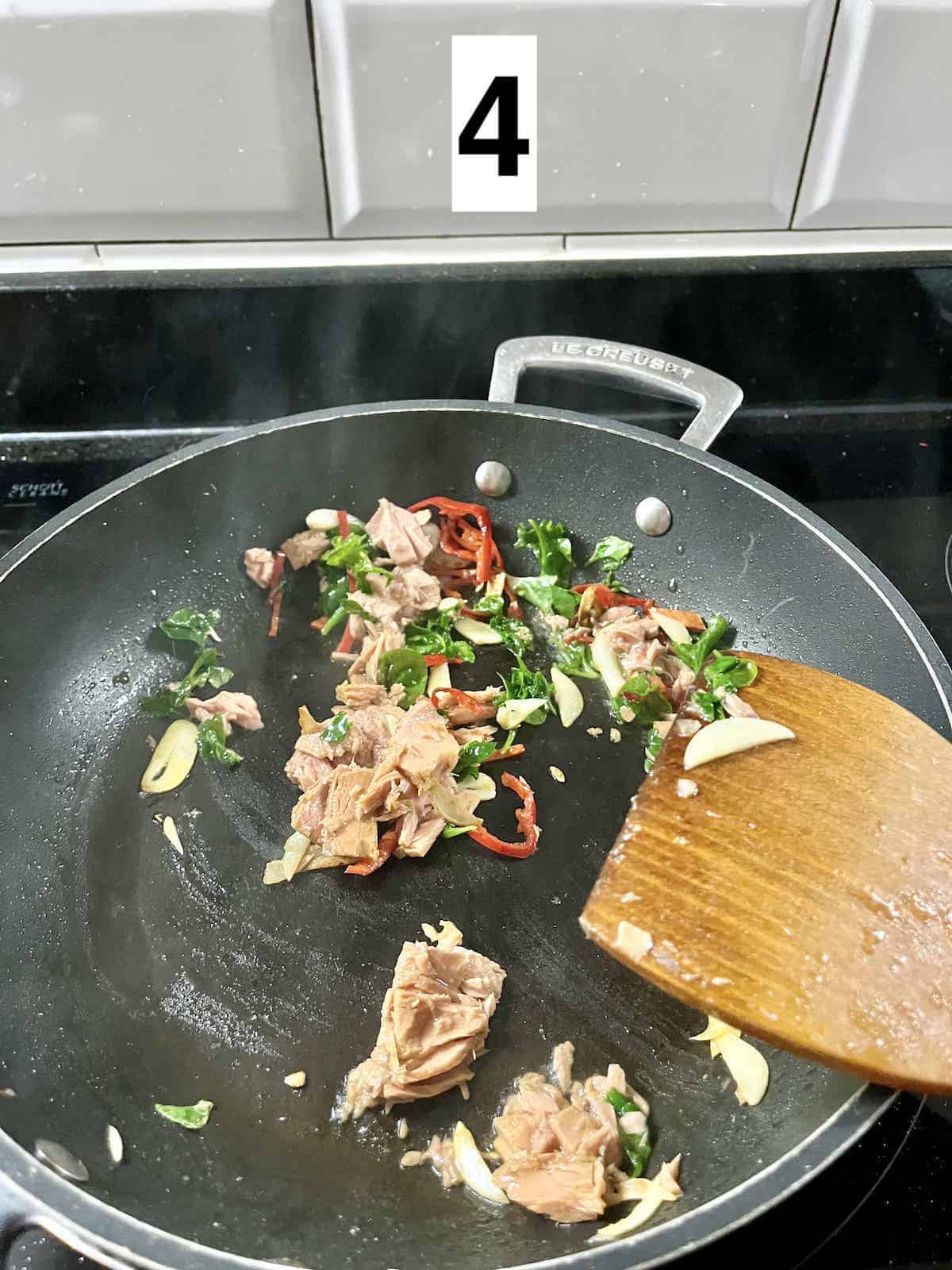 Stir-frying vegetables with tuna garlic and chilies.