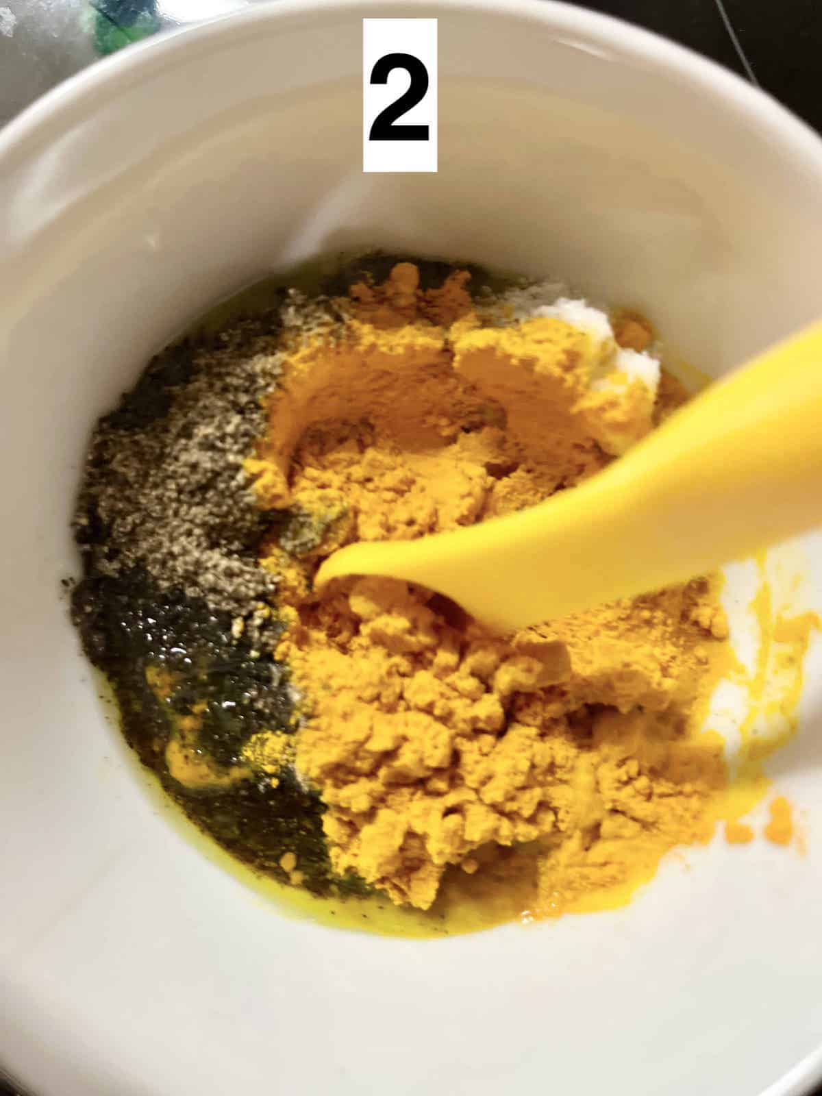 Mixing ground pepper, ground turmeric, salt, lime juice and olive oil.