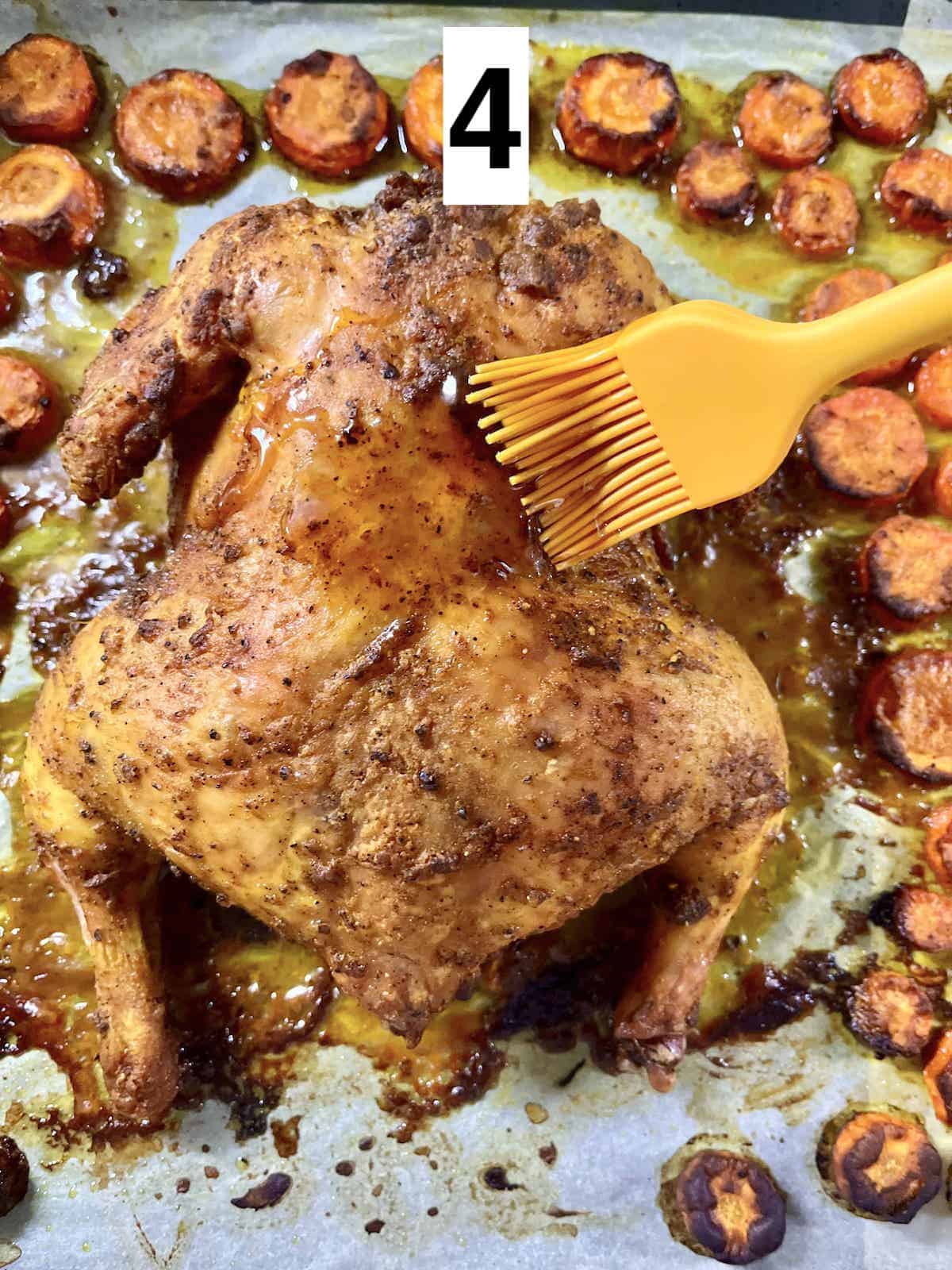 Brushing honey over roasted black pepper turmeric chicken.