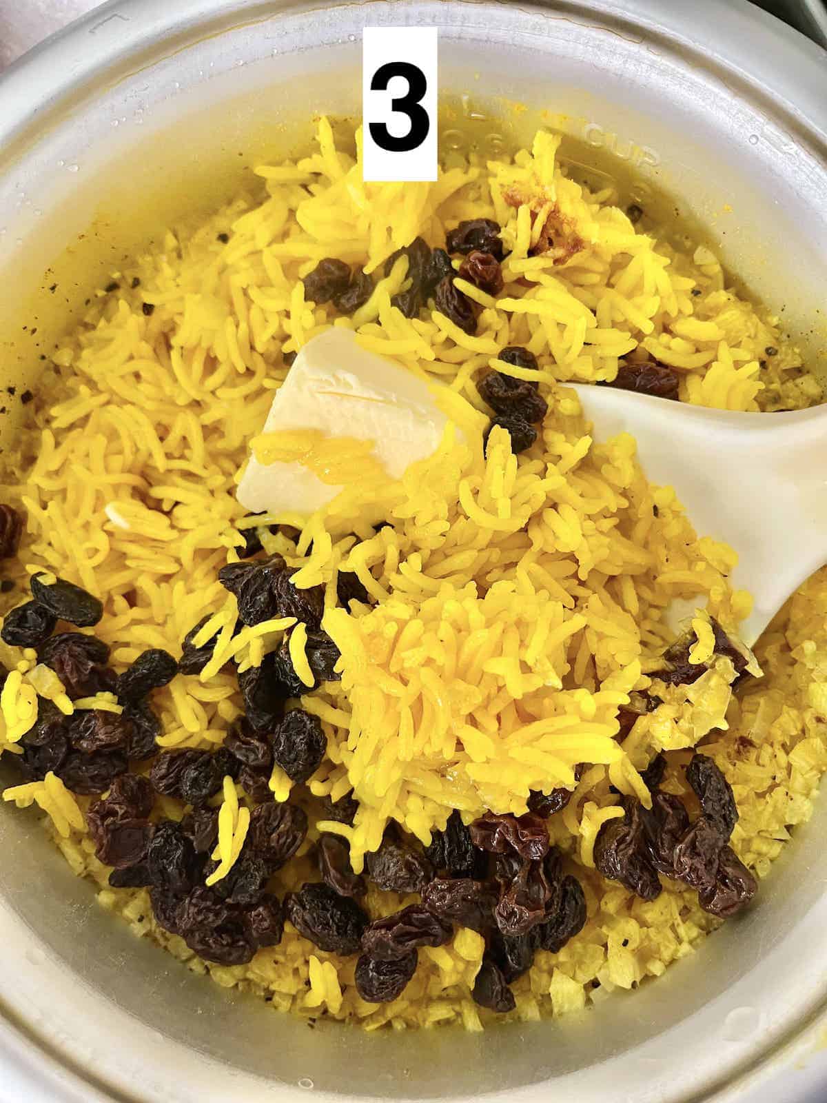 Stirring butter and raisins into golden rice.