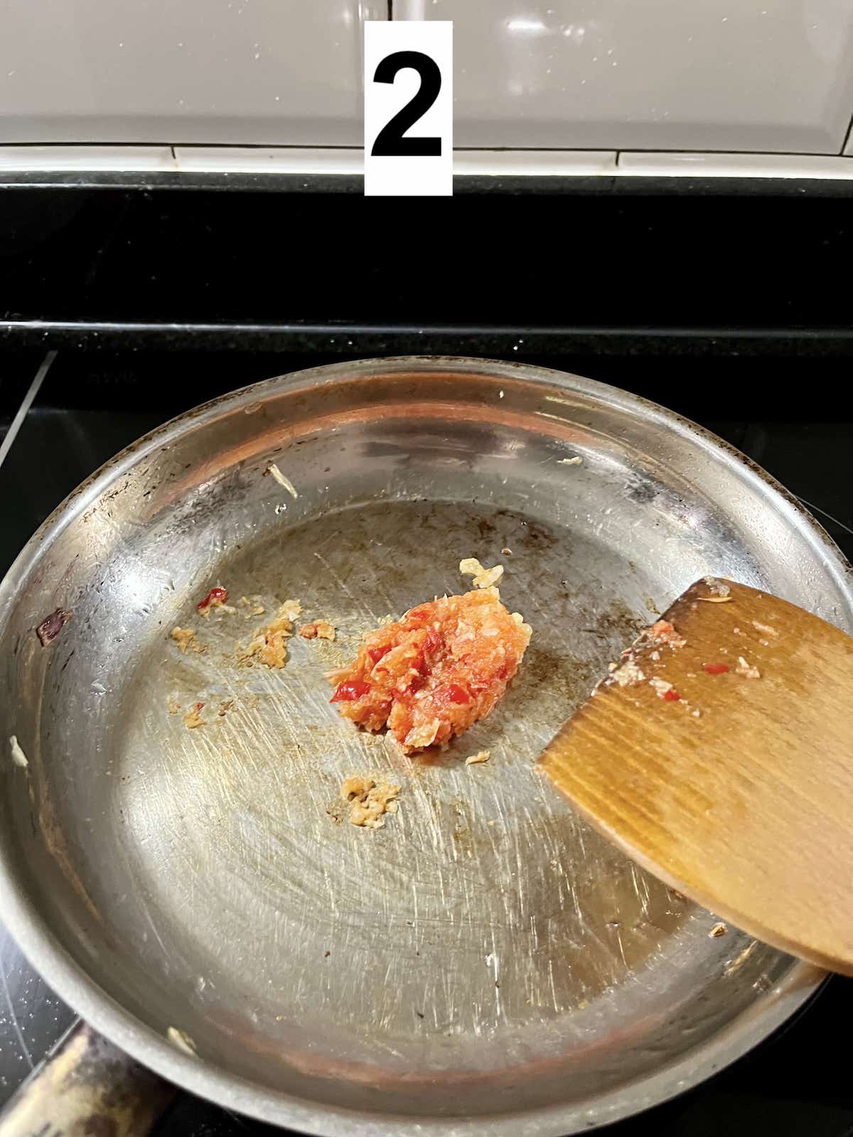 Stir-frying pounded chili and garlic paste.