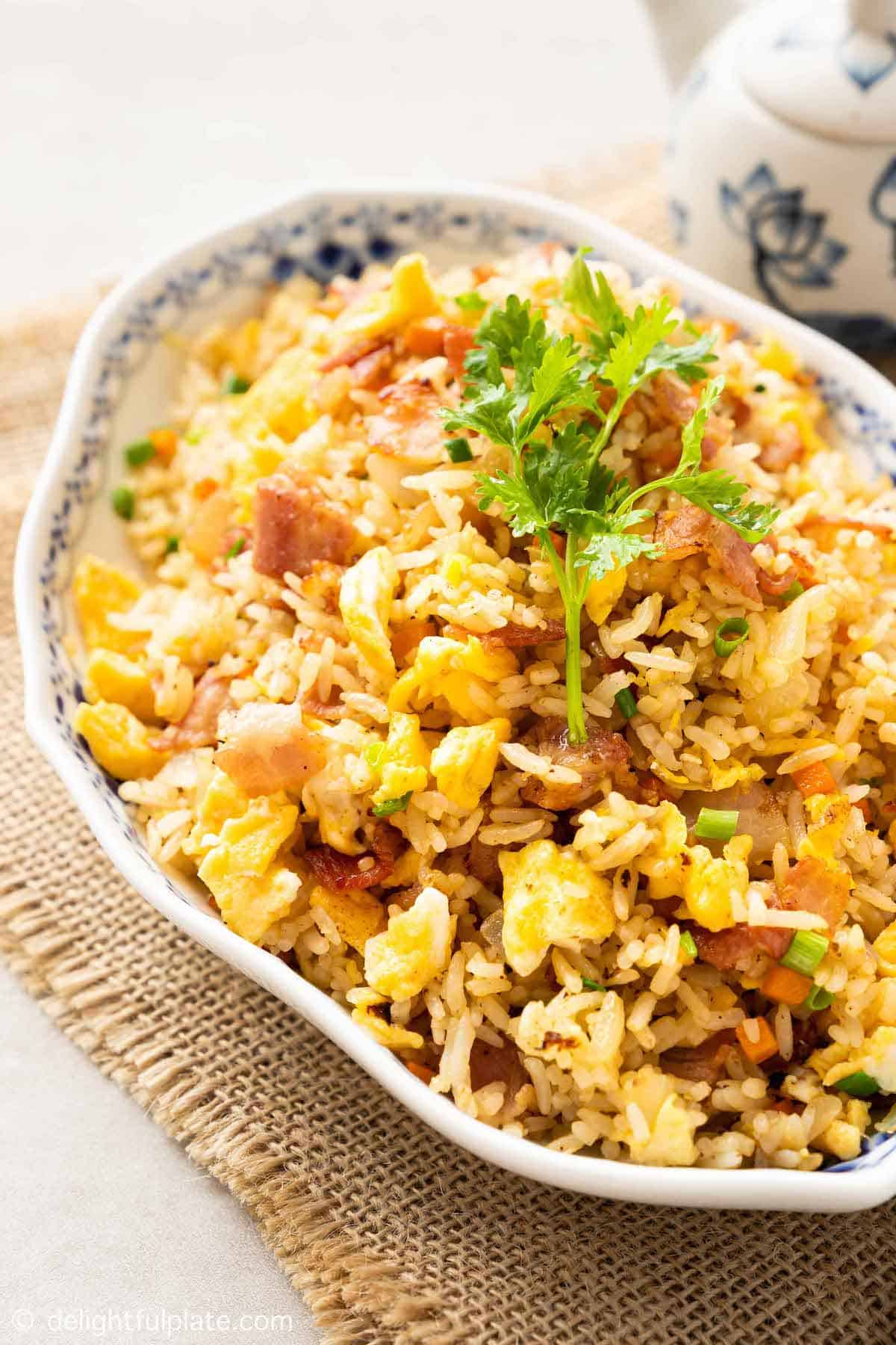 A platter of yellow fried rice with bacon