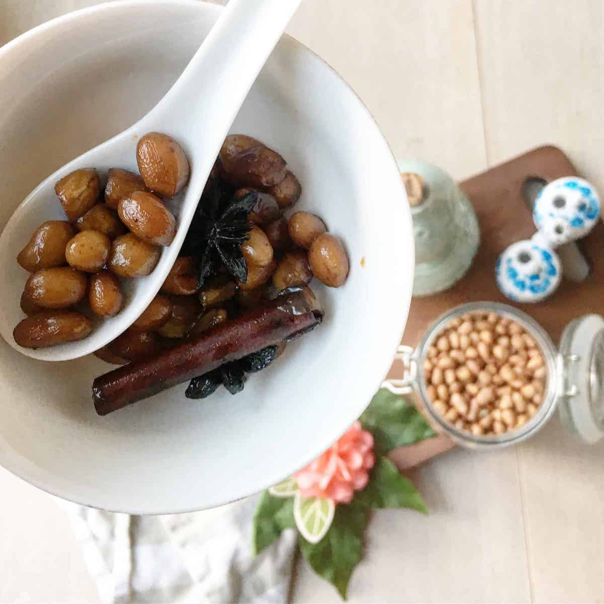 A scoop of braised Chinese peanuts with the ingredients in the background.