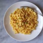 A plate of golden coloured cheese ramen