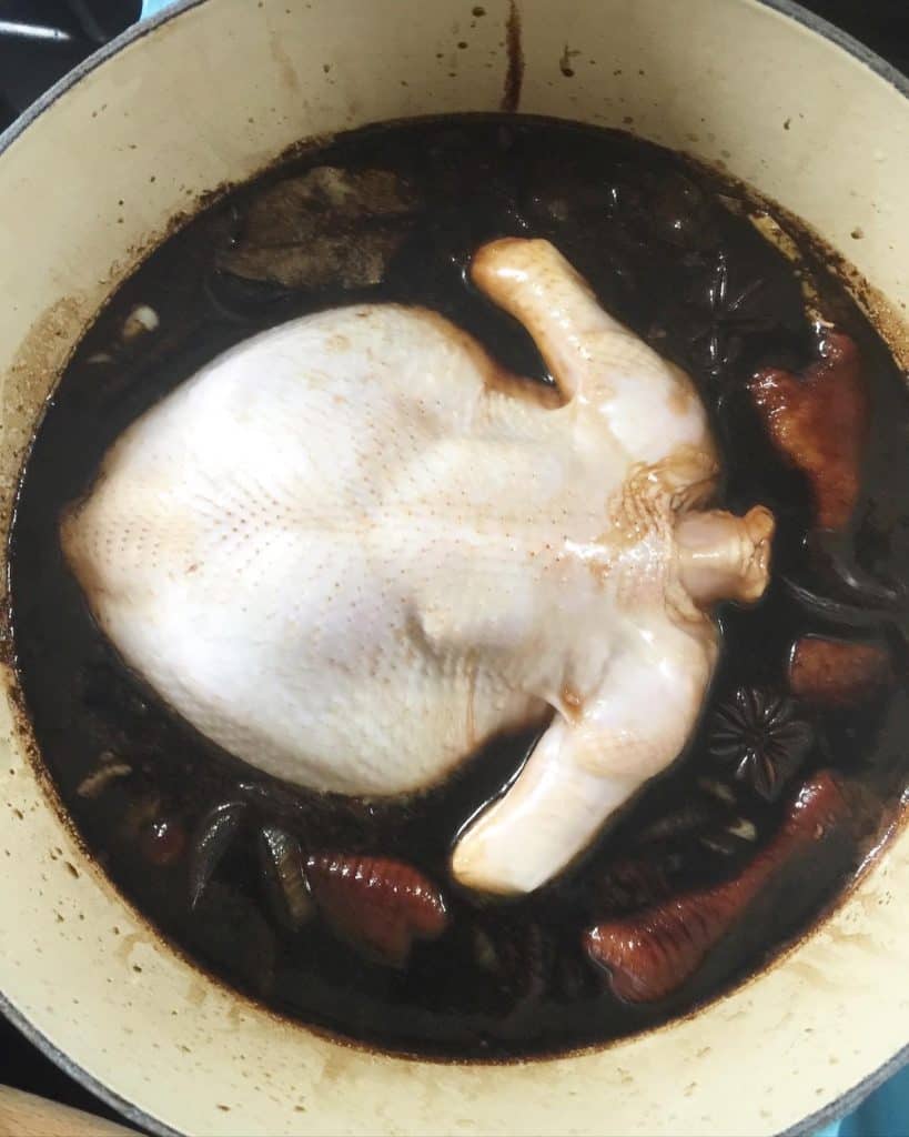Chicken poaching in a soya sauce sauce
