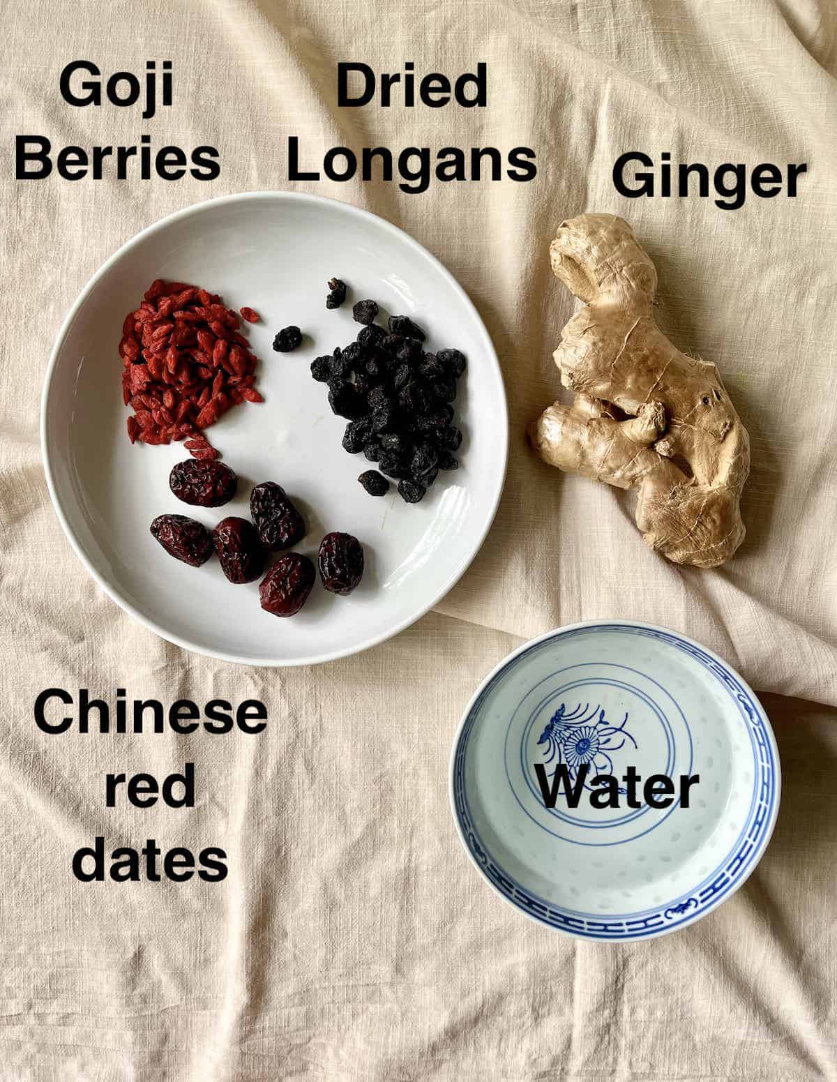 The 5 ingredients needed for longan red date herbal tea on a linen tablecloth.