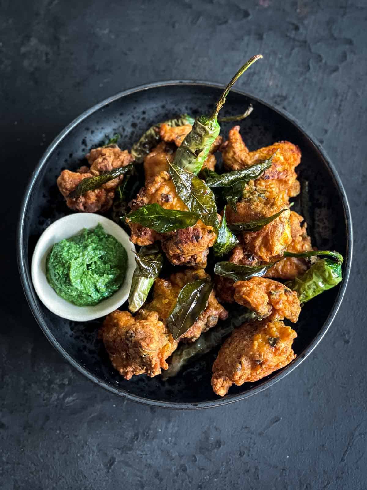 A plate of Indian Chicken Pakoras with sauce