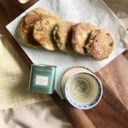 5 Korean hotteok pancakes on a serving board next to a cup of tea.