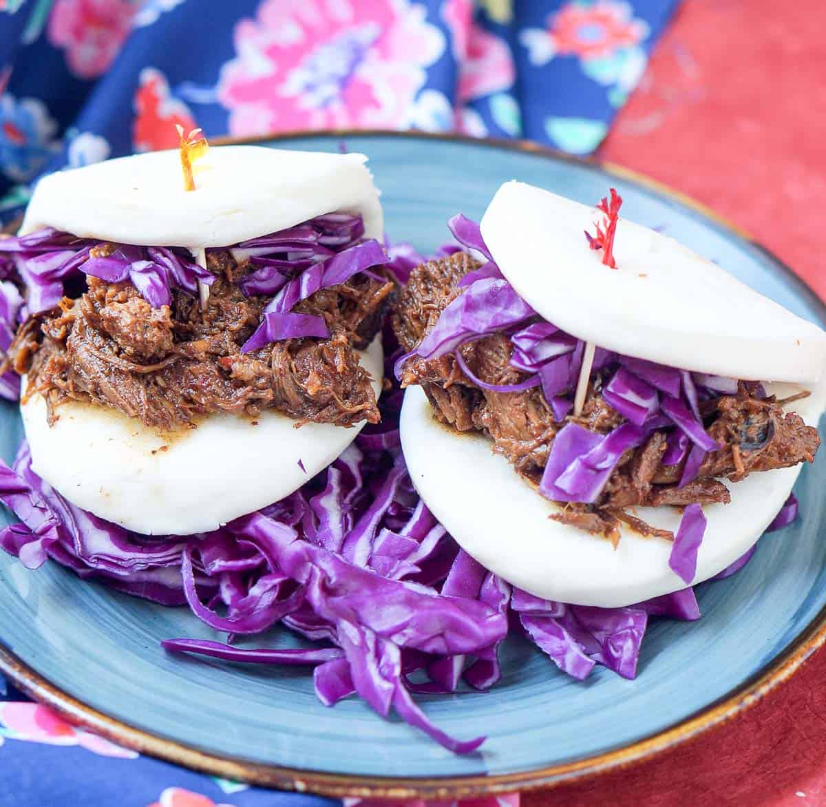 2 pork curry baos with red cabbage on a plate