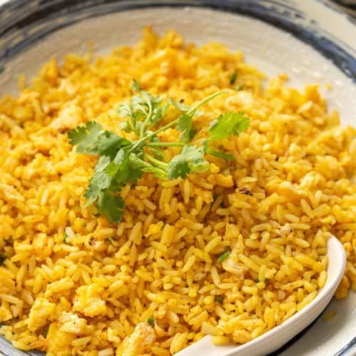 A close-up of salted egg fried rice with golden grains