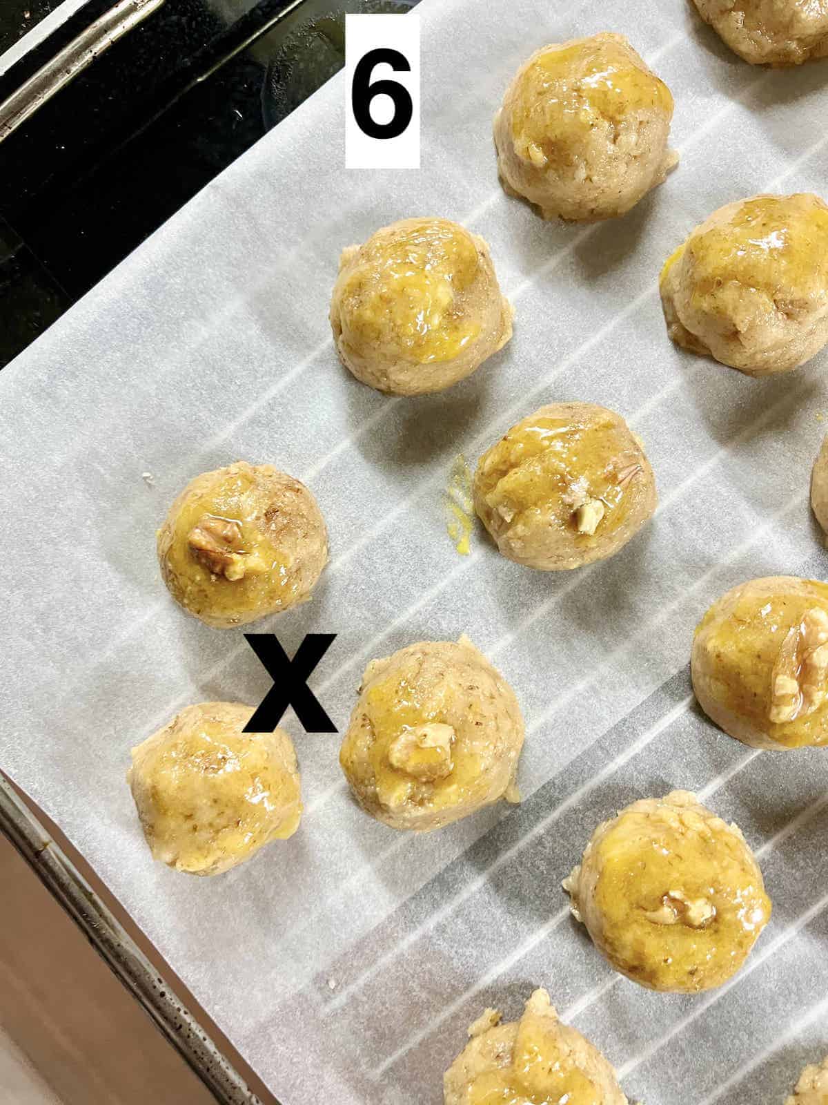 Raw walnut cookie dough balls on parchment paper.