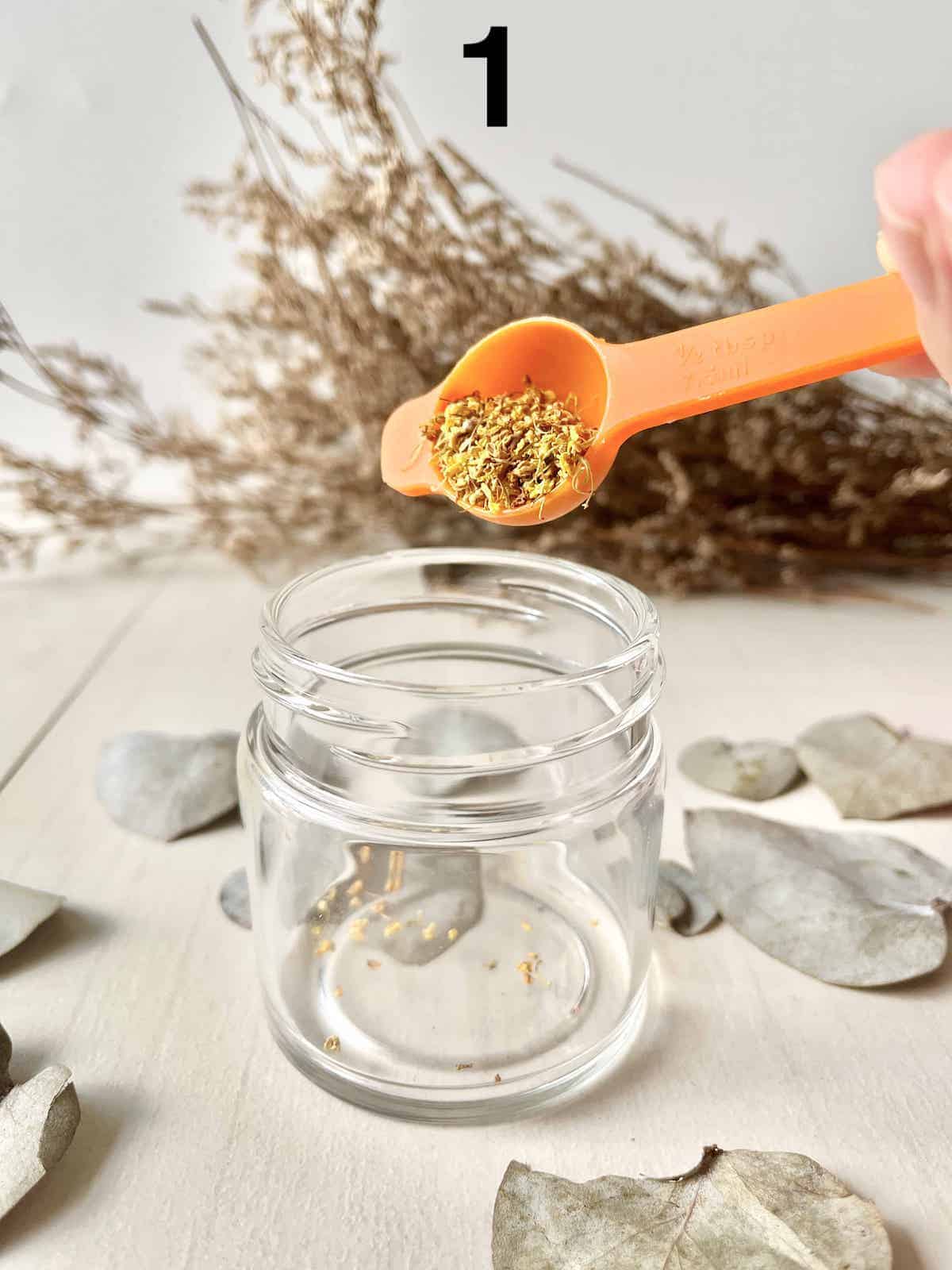 Pouring dried osmanthus flower tea into a glass cup.