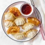 Golden steam fried potstickers on a plate