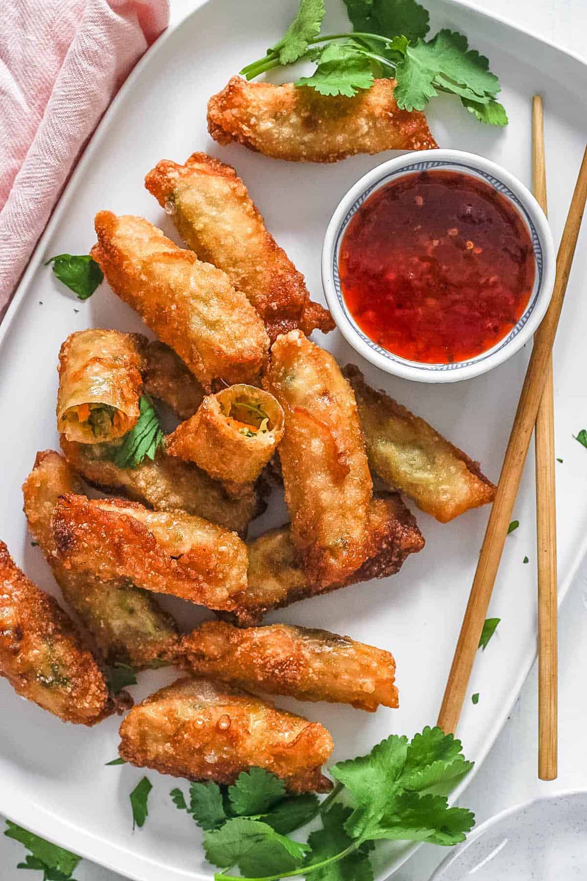 Well-fried vegan egg rolls on a white plate