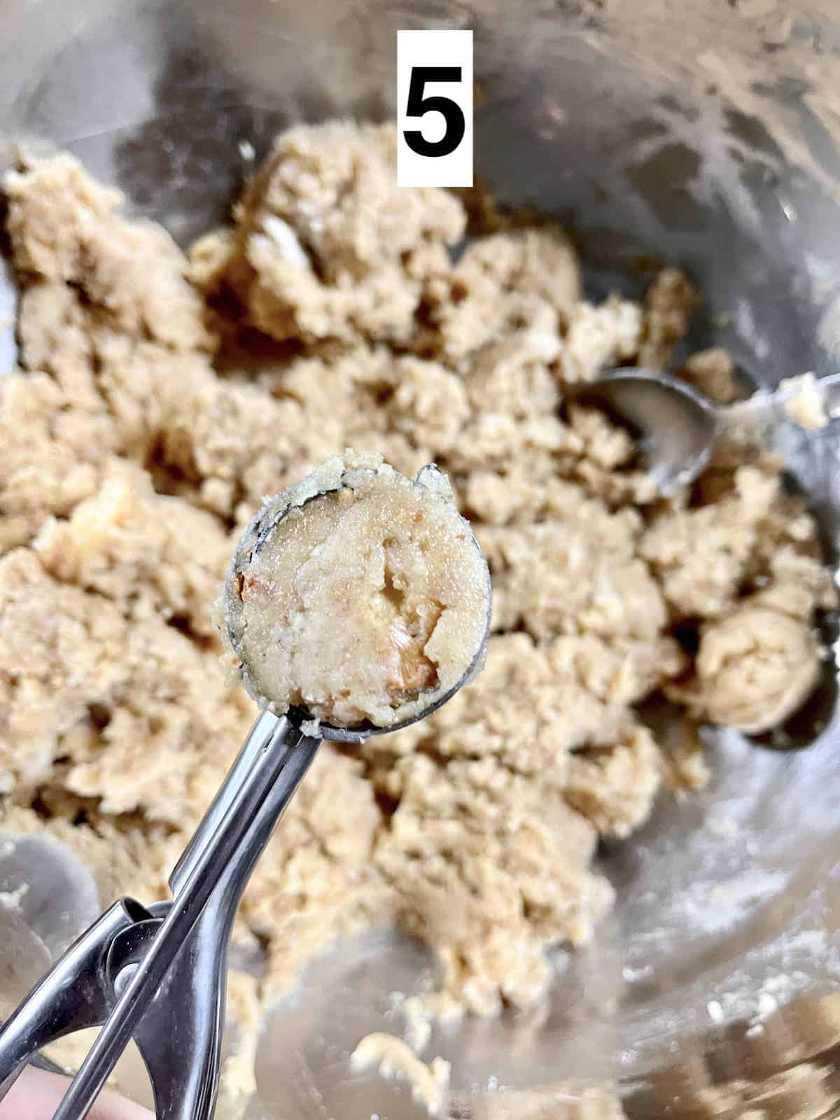 Scooping out walnut cookies using a small ice cream scoop.