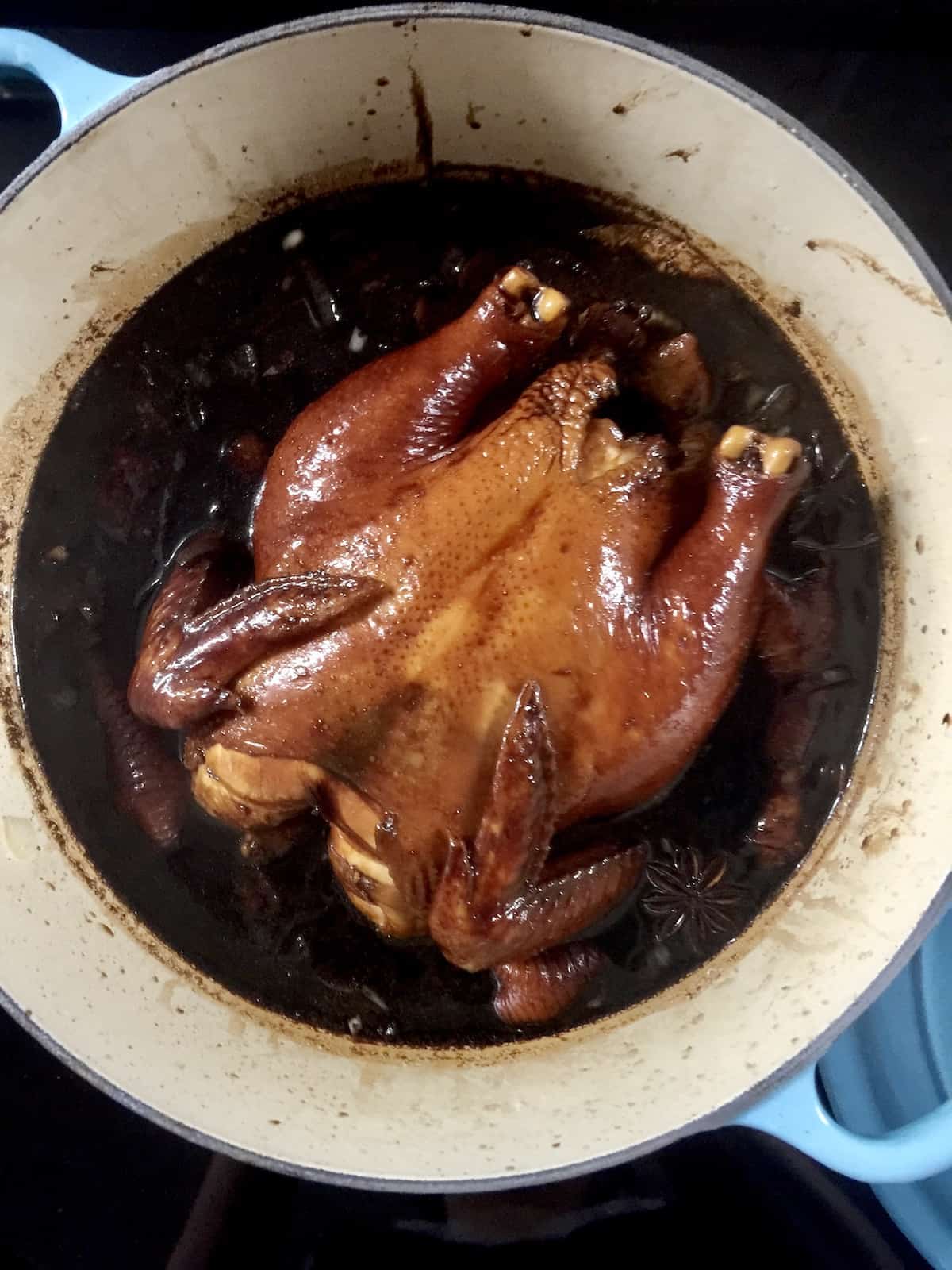 Close-up of chicken poached in dark soy sauce.