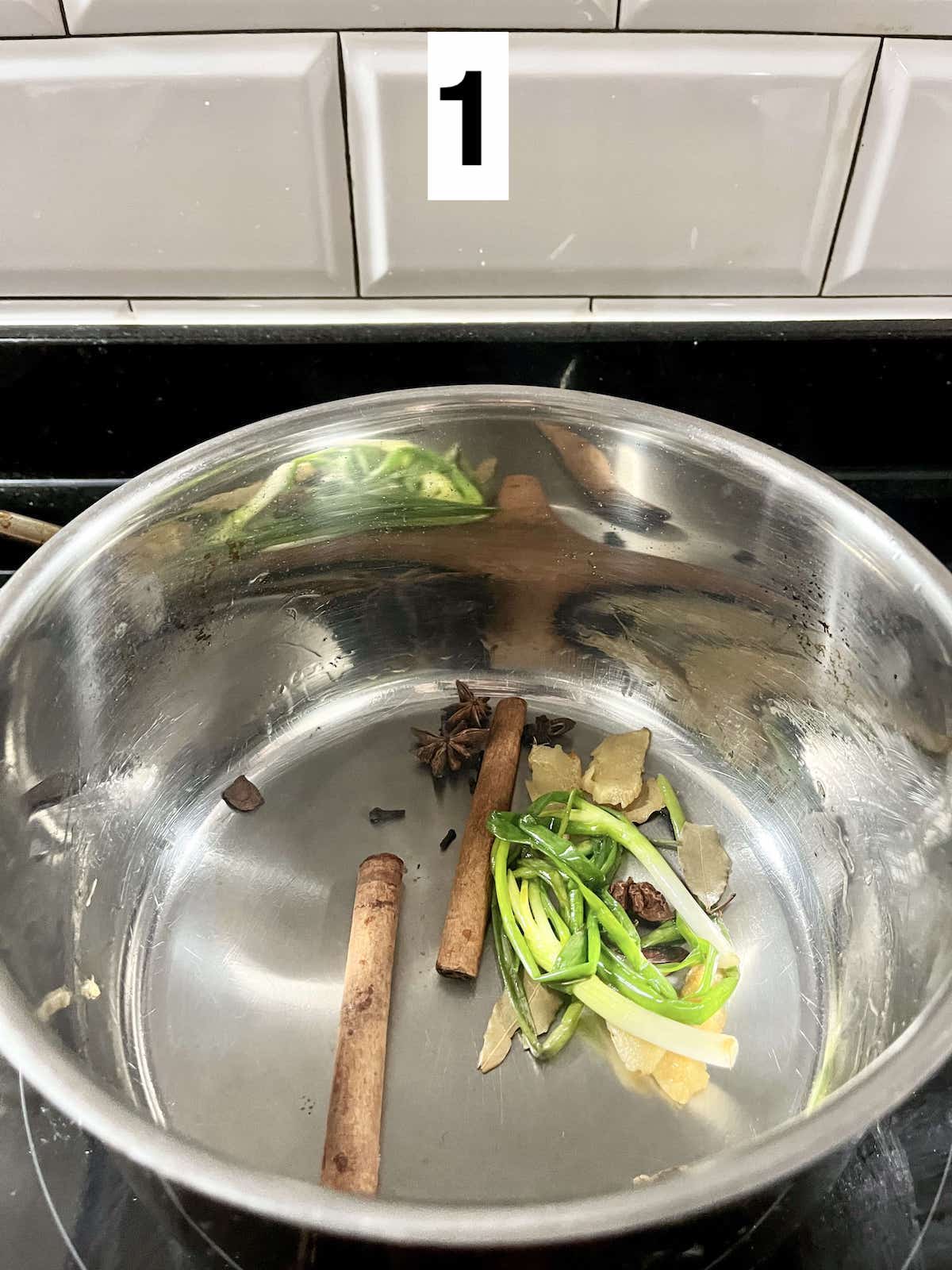 Sautéing scallions, ginger, cinnamon, bay leaves, star anise and cloves.