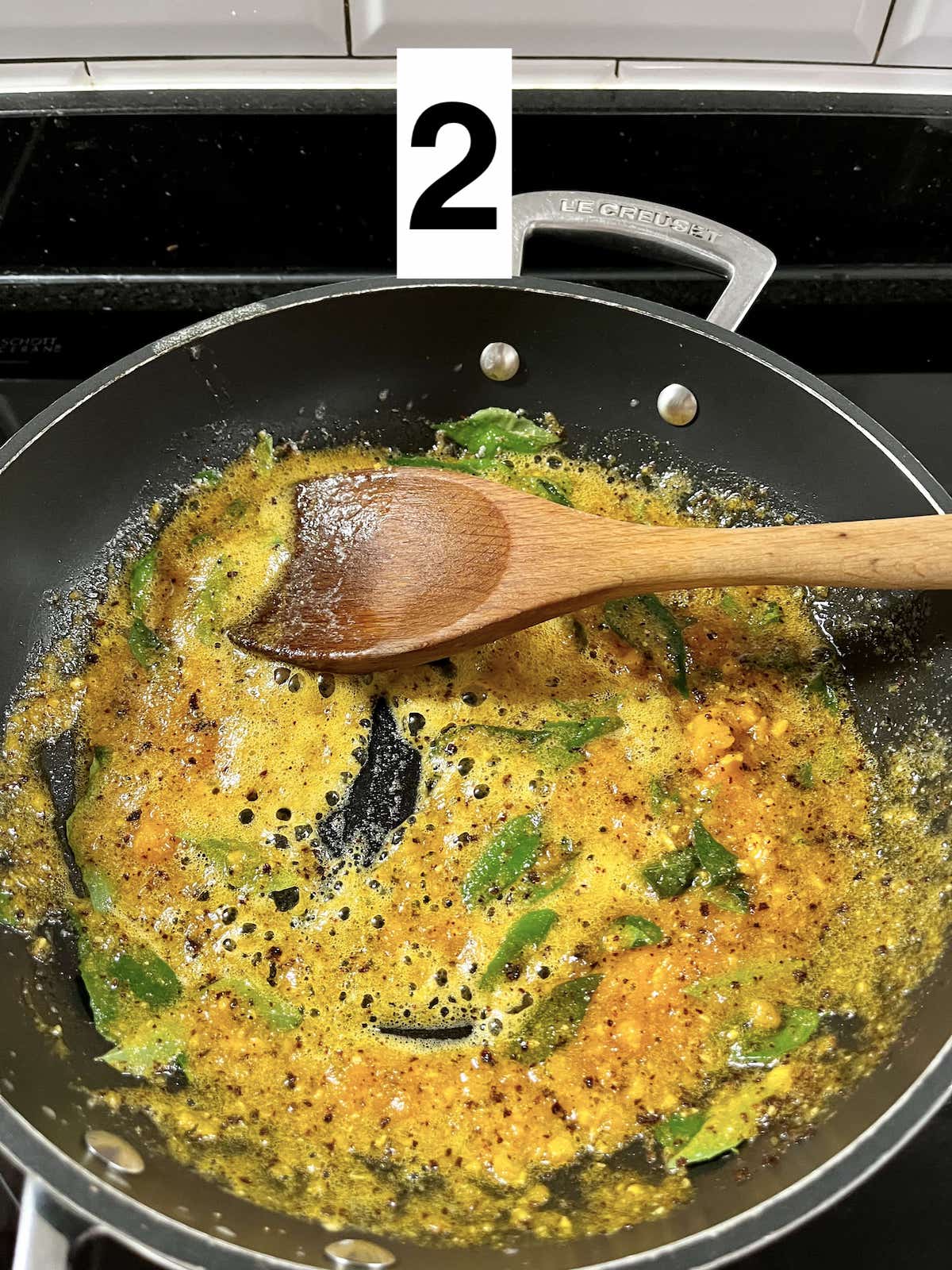 Sautéing melted butter with curry leaves, chili and mashed up salted egg yolks.