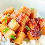 Close-up of tofu in a vegan orange sauce on rice