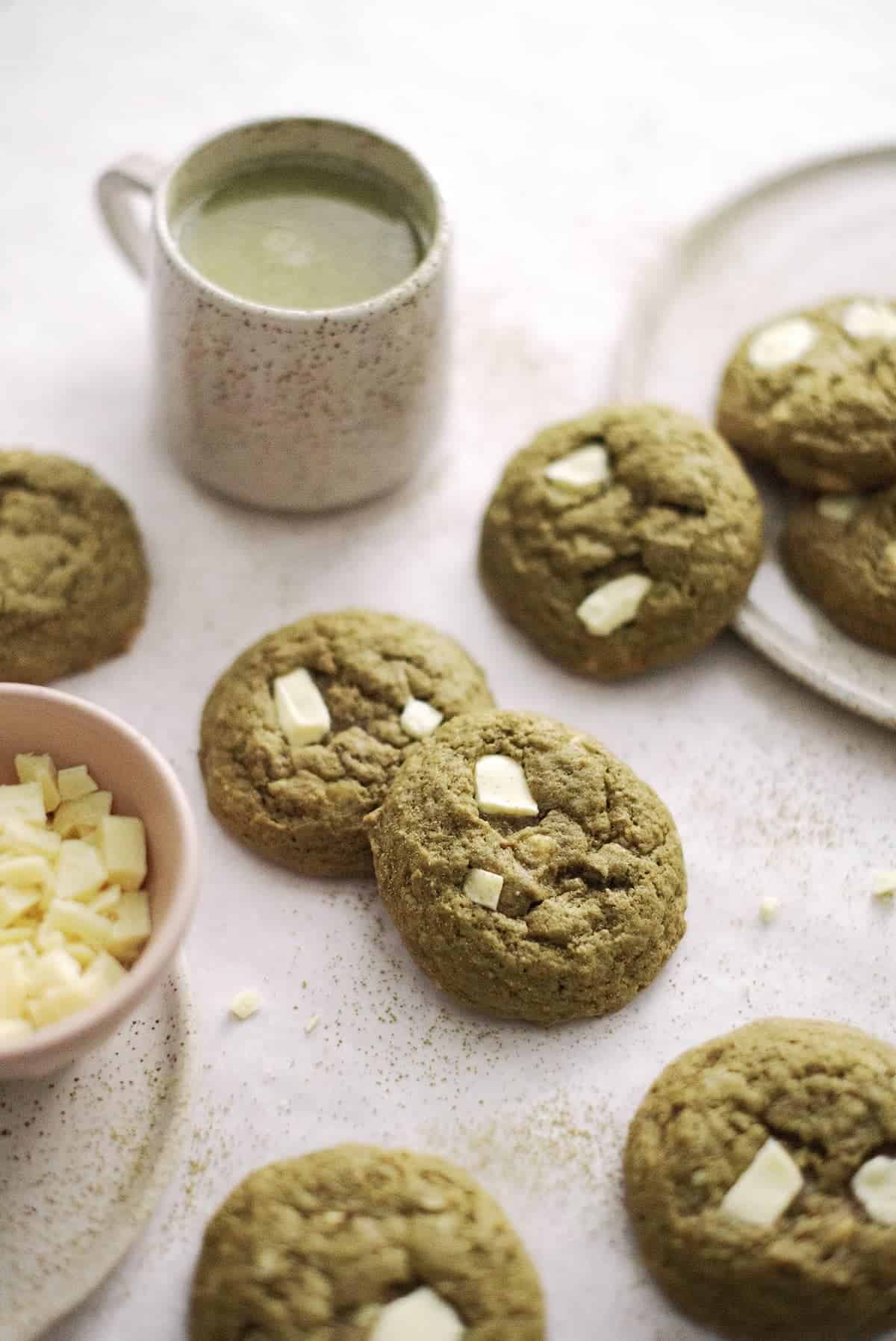 Several green matcha cookies spread on a table