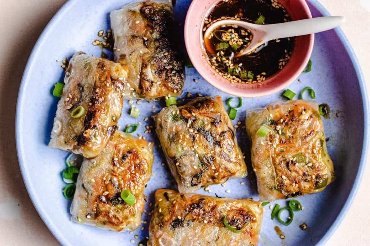 Rice paper dumplings on a blue plate with dipping sauce