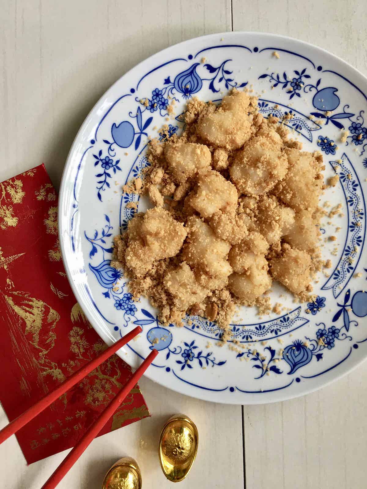 Muah chee- the Chinese equivalent of mochi- coated with peanuts on a white and blue plate