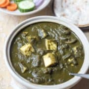 A bowl of green mushroom palak paneer.