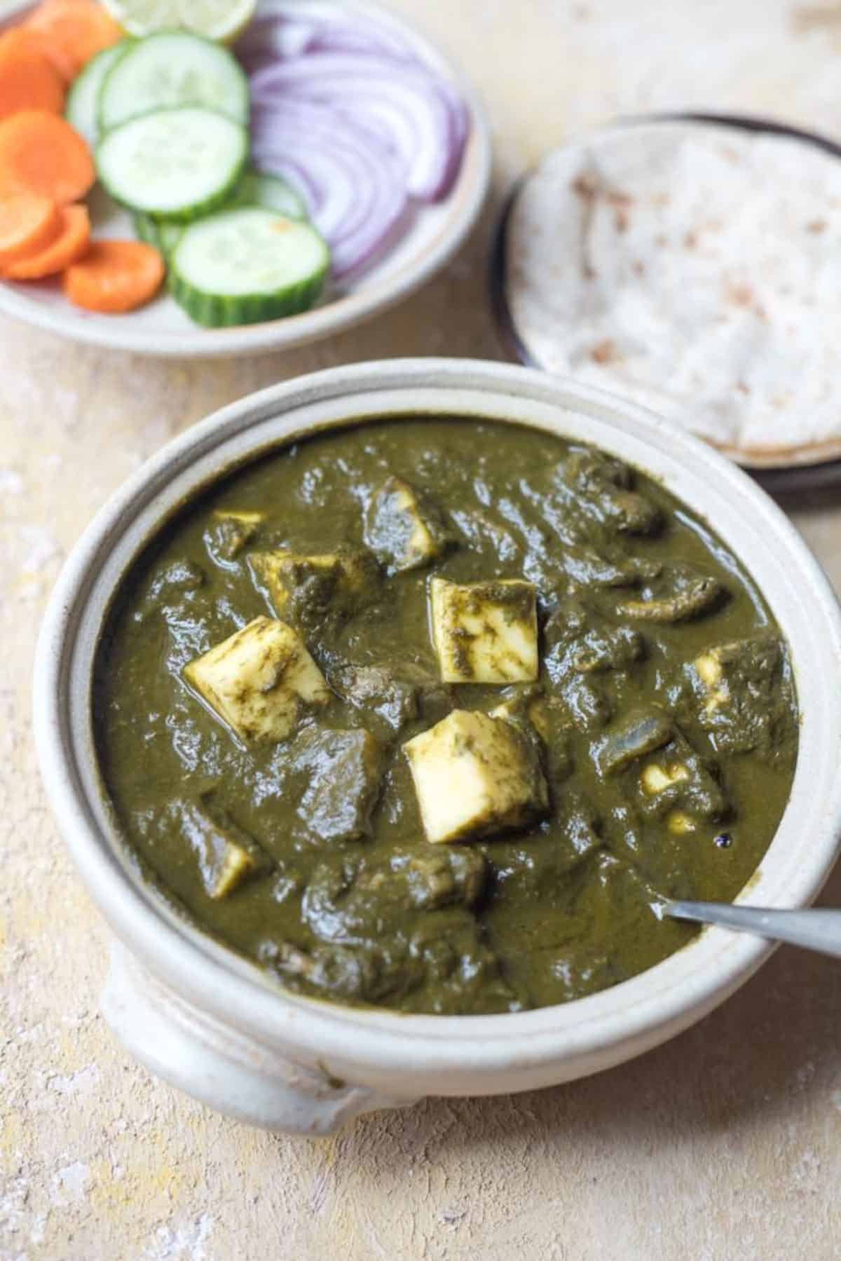 A bowl of green mushroom palak paneer.