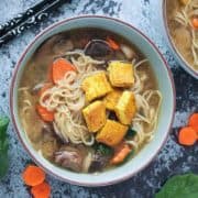 A bowl of Asian-inspired noodles with tofu on top.